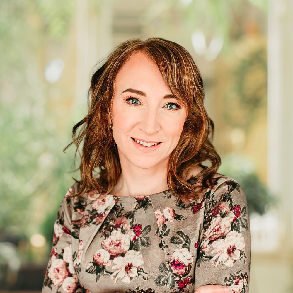 A woman with long hair wearing a floral dress.