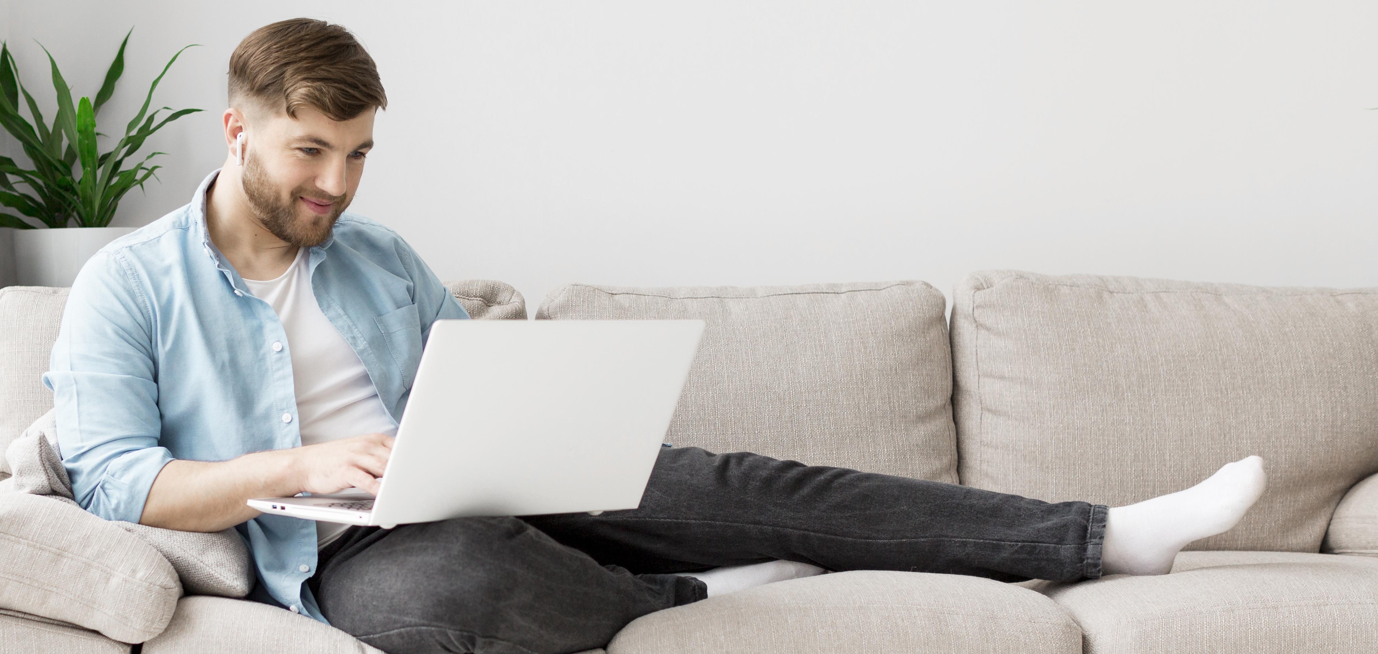 A woman with a cheerful expression, using her laptop, fully engaged in her tasks.